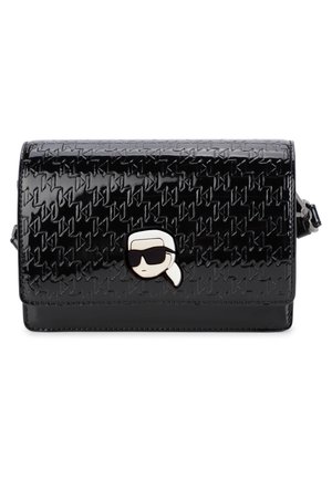 Czarna kopertówka z lakierowanej skóry z tłoczonym wzorem i małym metalowym emblematem przedstawiającym twarz w ciemnych okularach przeciwsłonecznych i z białym kucykiem.