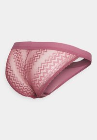 Slip in pizzo rosa caratterizzato da motivi a zig zag, bordi senza cuciture e una cintura liscia. Realizzato in un materiale morbido e traspirante con una delicata texture.