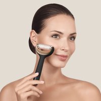 Zwarte gezichtsroller met een ronde, textuurrijke, transparante kop. De handgreep is breed en ergonomisch. De achtergrond is lichtbeige.