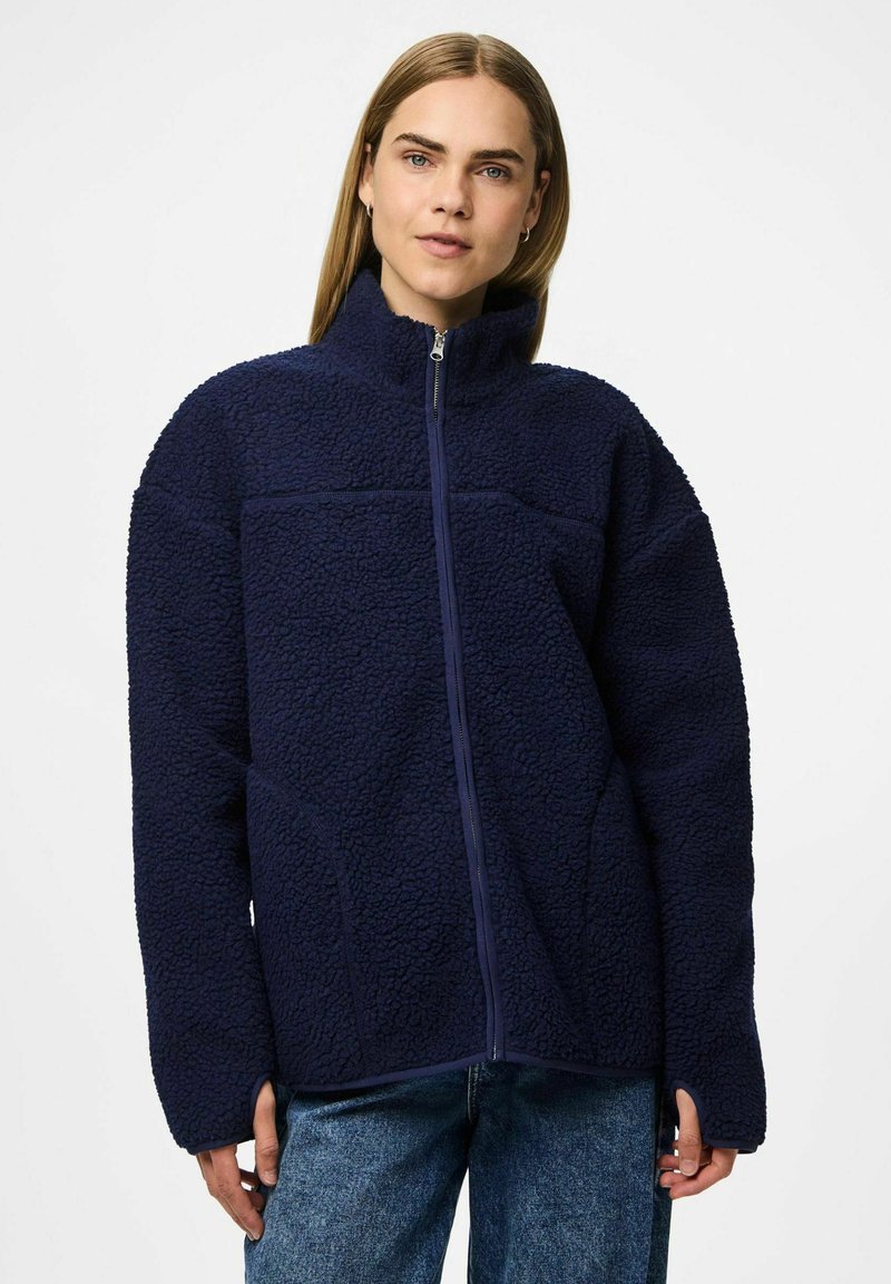 Marinblå fleecejacka med hög krage, dragkedja framtill och texturerad yta. Oversized-passform med vida ärmar och sidofickor.