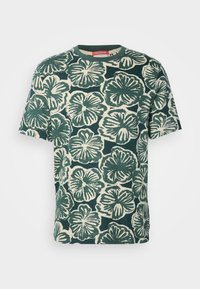 Green floral short-sleeve t-shirt with a cream background, featuring a bold hibiscus pattern. Crew neckline and soft texture.