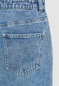 Jeans in denim blu chiaro con una singola tasca posteriore dotata di una patta curvata. Il tessuto presenta una finitura leggermente strutturata e cuciture visibili.