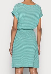 Raidallinen, lyhythihainen mekko turkoosissa ja valkoisessa, rento malli, jossa on vyötärölle kiristävä kohta, pehmeä materiaali ja polvenmittainen helma.