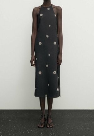 Schwarzes Leinenkleid mit einem Neckholder-Ausschnitt, featuring kreisförmige Stickmuster, knielanger Schnitt und Seitenschlitze für mehr Bewegungsfreiheit.
