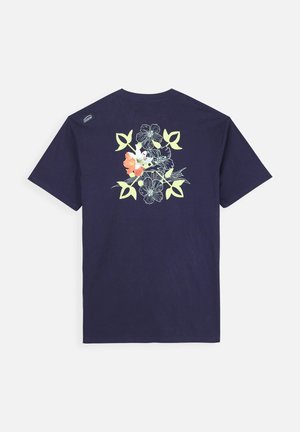 T-shirt en coton bleu marine avec un graphique floral en blanc et orange au dos, à manches courtes et au design col rond.