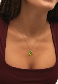 Collar de cadena de oro con un encantador charm esmaltado y colorido con forma de caracol verde, con un ojo rojo y un acento amarillo.