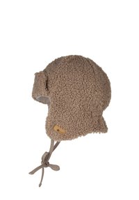 Fleece-lined beige hat with ear flaps, textured surface, and a brown leather tag; features a tie at the chin for secure wear.
