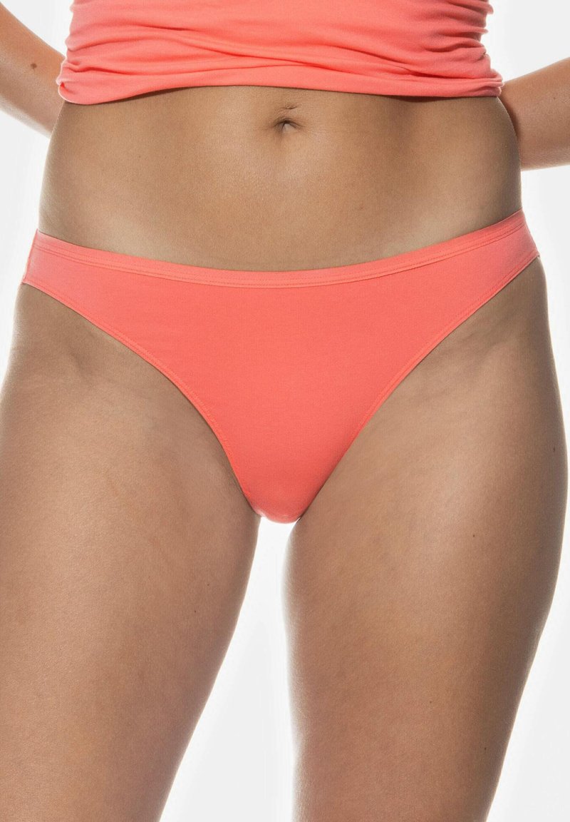 Korallfärgad bomullstrikiniundertøy med mjuk elastisk kant, låg midje-design och slät textur, med minimalistisk stil och utan mönster.