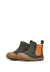 Bottines en daim vert avec des accents latéraux élastiques orange et des semelles en caoutchouc texturé, présentant un bout arrondi et une hauteur courte.