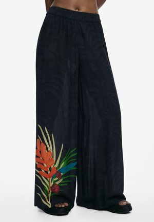 Black wide-leg pants made of lightweight fabric, featuring a tropical floral design in orange and green on the lower left side.