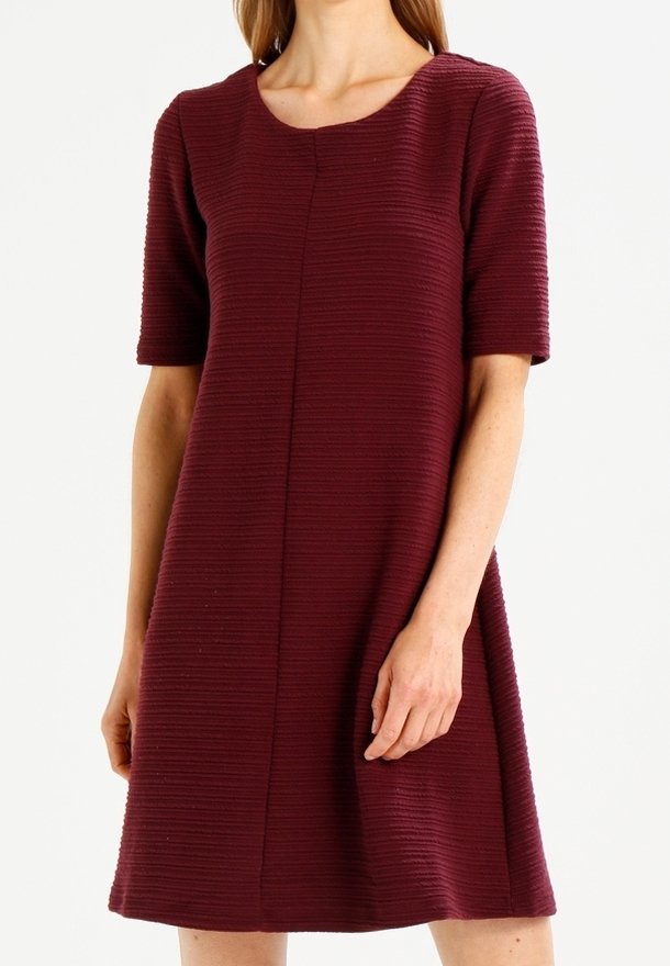 Robe bordeaux à manches courtes avec un motif texturé et côtelé, présentant un col rond et une silhouette en A qui tombe au-dessus du genou.