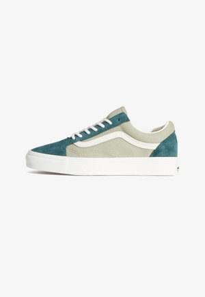 Lage sneakers van groen en crèmekleurig canvas met suède accenten, voorzien van witte veters en een textuurprofiel van rubberen zool.