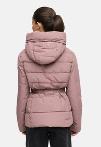 Vadderad jacka i dämpad rosa med en bred huva, midjebälte och vadderad design. Har ett logodetalj på baksidan och strukturert tyg.
