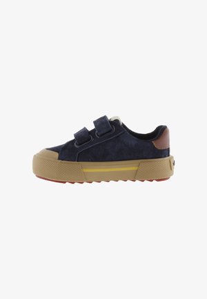 Sneaker da bambini blu navy con due strap a velcro, suola in gomma color marrone chiaro con striscia gialla e toppa in pelle marrone sul tallone.