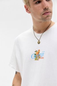Hvid bomulds t-shirt med et farverigt grafisk print af en drink og teksten "Orenji Jusu." Rund halsudskæring og korte ærmer.