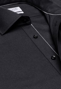 Schwarze Button-Down-Hemd aus strukturiertem Stoff, mit einem klassischen Kragen, schwarzen Knöpfen und subtilen weißen Akzenten entlang der Knopfleiste.