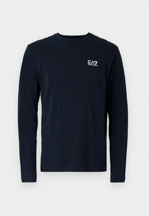 Zila garām piedurknēm T-kreklu izgatavots no kokvilnas, ar apaļu kaklu un mazu baltu EA7 logotipu kreisajā krūtī. Gluda tekstūra.