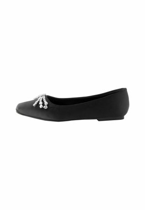 Chaussure plate noire à bout pointu avec un groupe d’ornements en strass argentés près de l’avant.