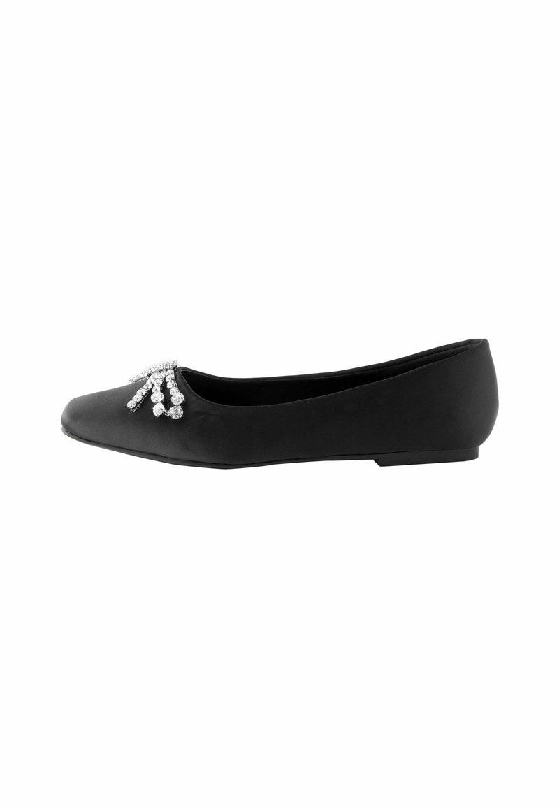 Chaussure plate noire à bout pointu avec un groupe d’ornements en strass argentés près de l’avant.