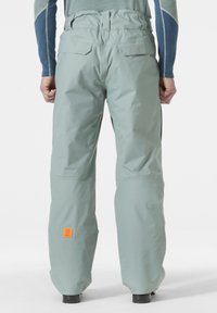 Heren waterdichte skibroeken in lichtgroen, met een wijdere pijpdesign, achterzakken en een oranje logo op de onderzijde.