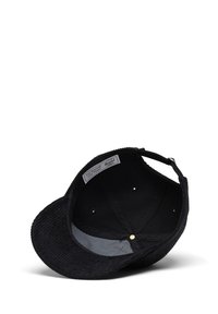 Gorra de pana negra con visera plana. El interior presenta un patrón de rayas con una etiqueta de marca cosida en su interior. Acentuada con detalles dorados.