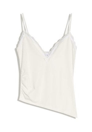 Caraco blanc sans manches avec bordure en dentelle et fines bretelles doubles, doté d'un décolleté en V et d'un léger froncé sur le côté.