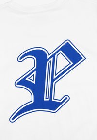 Biała koszulka z dużym niebieskim graficznym logo. Logo ma wyraźne, ostre krawędzie z kontrastującą obwódką, co tworzy wizualną głębię.