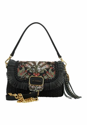 Borsa La Carrie nera con ricamo floreale, rifinitura intrecciata, dettagli a frange, tracolla a catena dorata e nappina su sfondo bianco.