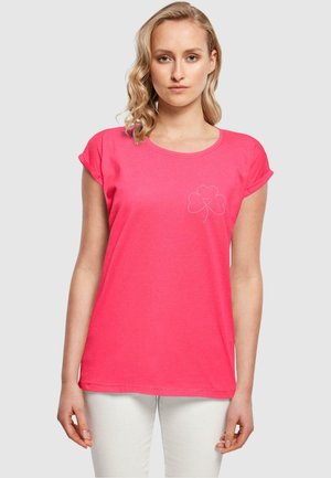 Pink cotton t-shirt with rolled sleeves, round neck, and white embroidered clover design on the chest. Fit is relaxed and casual.