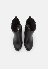 Czarne skórzane botki za kostkę o gładkiej fakturze, z okrągłym noskiem i z boku zamkiem błyskawicznym. Wnętrze wyłożone miękkim materiałem dla komfortu.