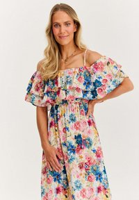 Kwiatowa sukienka na jedno ramię z falbaniastego rękawa, w pastelowo-różowym tle, z żywymi niebieskimi i różowymi kwiatami oraz elastycznym pasem.
