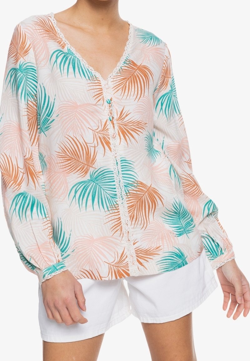Blusa leggera a maniche lunghe con scollatura a V, con un motivo di foglie tropicali in turchese e arancione su sfondo bianco, e dettagli in pizzo.