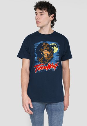 Navy blue cotton t-shirt featuring a graphic of a wolf's head and the text "Teen Wolf" in red, with a full moon backdrop and blue accents.