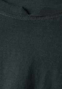 Mörkgrå T-shirt-tyg med en slät textur, med en nära passande V-ringning och synliga, välsydda sömmar.