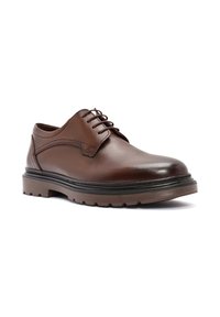 Bruine leren oxford schoen met een ronde neus, vetersluiting, gestructureerd oppervlak en dikke rubberen zool met diepe groeven voor grip.
