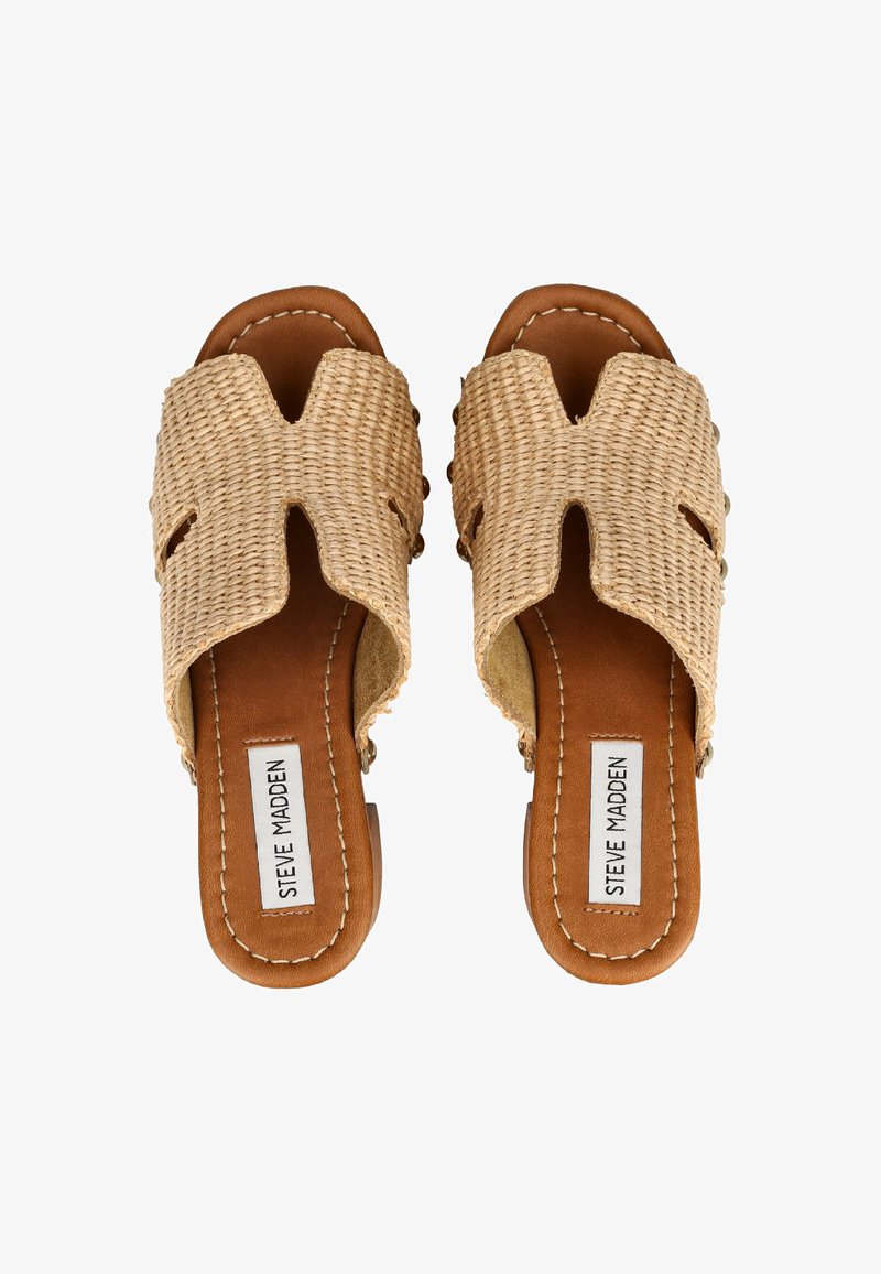 Ζευγάρι σανδαλιών διχτυωτού με ταμπά δερμάτινη σόλα και επάνω μέρος από πλεκτό μπεζ ύφασμα με ετικέτα "Steve Madden" στο εσωτερικό κάθε πάτου.