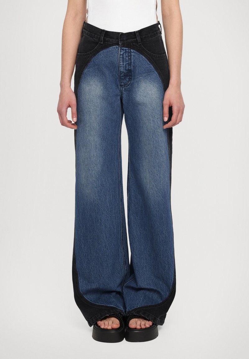 Wide-leg jeans made of denim featuring a color-block design: dark blue on the sides, light blue center, with a smooth texture and high waist.