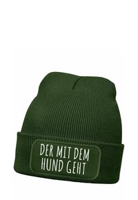 Green beanie hat with ribbed texture and a folded cuff, featuring a white rectangular patch with the text "DER MIT DEM HUND GEHT."