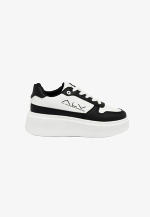 Zwart-witte sneaker met een gestructureerde bovenkant, ronde neus, dikke witte zool en zwarte accenten. De veters zijn wit met ronde oogjes.