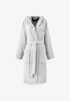 Accappatoio in cotone grigio con finitura testurizzata. Caratterizzato da cappuccio, maniche lunghe, cintura e due tasche frontali. Logo Lacoste sul petto.