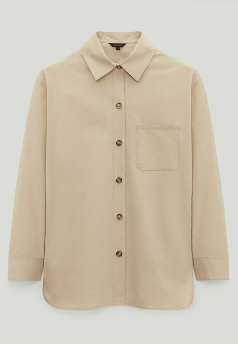 Chemise beige à manches longues avec boutons, col pointu et une seule poche poitrine côté gauche.
