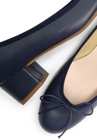 Ballerine blu navy in pelle testurizzata, con punta rotonda, tacco a blocco piccolo e un fiocco decorativo nella parte anteriore.
