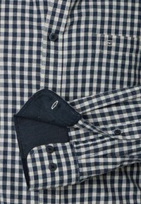 Short-sleeve checkered shirt in navy and white, featuring a button-up front, a patch pocket, and contrasting navy cuffs.