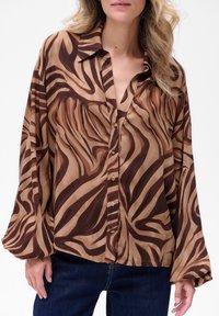 Bruine blouse met een patroon, gemaakt van lichtgewicht stof, met een kraag, knopenlijst aan de voorkant en lange mouwen met een ontspannen pasvorm.