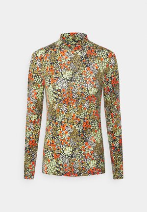 Haut à col montant et manches longues avec un motif floral dense en orange, jaune, blanc et vert sur un fond noir.