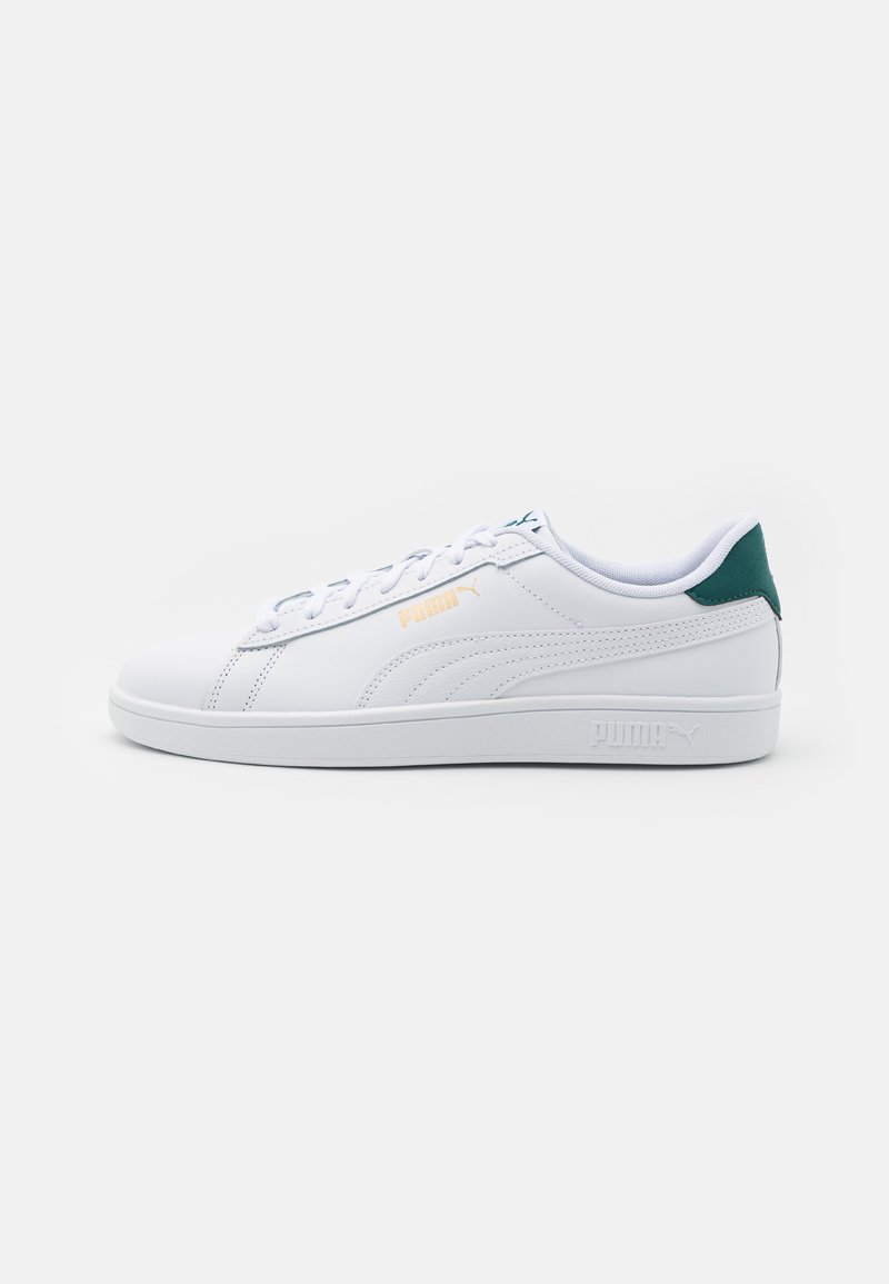 Hvide sneakers med en glat syntetisk overdel, grøn hælaccent og orange logo. Har en flad gummisål og snørebåndsdesign.