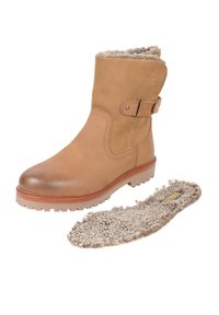 Brązowy zamszowy botek z zaokrąglonym noskiem, boczną klamrą i gumową podeszwą; posiada wyjmowaną beżową wkładkę ze skóry owczej.