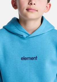 Felpa azzurra chiara in tessuto morbido, con tasca a marsupio e cappuccio regolabile con cordino. Logo "element" stampato in blu navy.