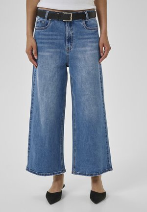 Wide-leg blue jeans made of denim, featuring a high waist, frayed hem, and a black belt with a silver buckle. Textured fabric with subtle fading.
