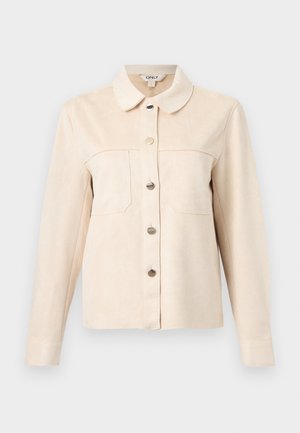 Μπεζ πουκάμισο με κουμπιά και μακριά μανίκια, με δύο τσέπες στο στήθος και μύτη στο γιακά, τοποθετημένο σε ανοιχτό γκρι φόντο.